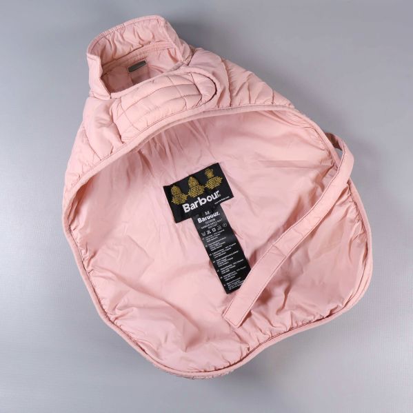 Insidan av ljusrosa hundjacka med etiketter synliga