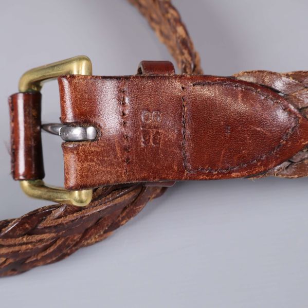 Detaljbild på bältets spänne och präglad storleksmärkning i lädret