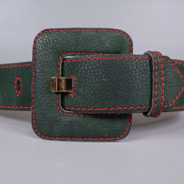 Närbild på skärpets spänne och röda sömmar