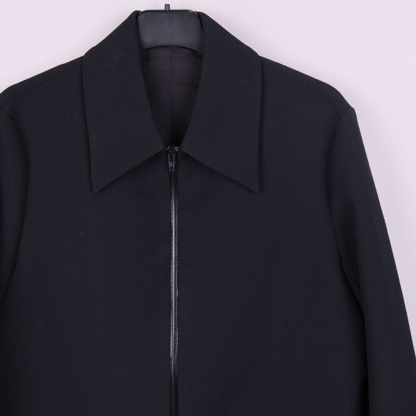 Närbild på krage och dragkedja på svart jacka