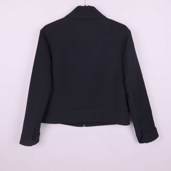 Svart jacka sedd bakifrån med enkel design och raka ärmar