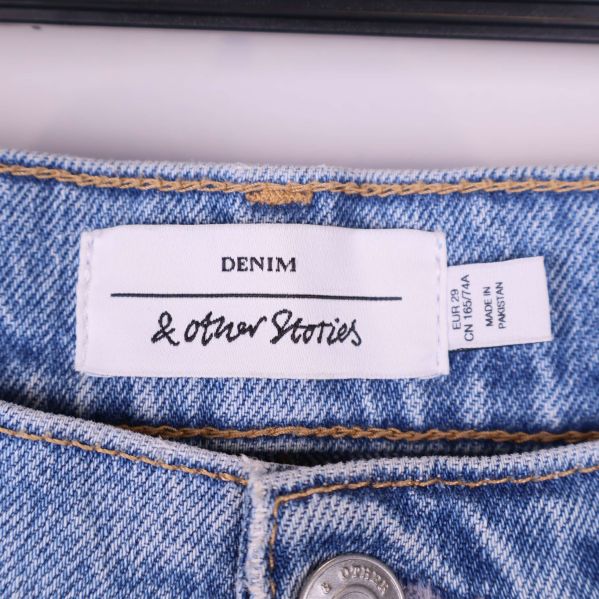 Närbild på märke med texten & Other Stories i linning