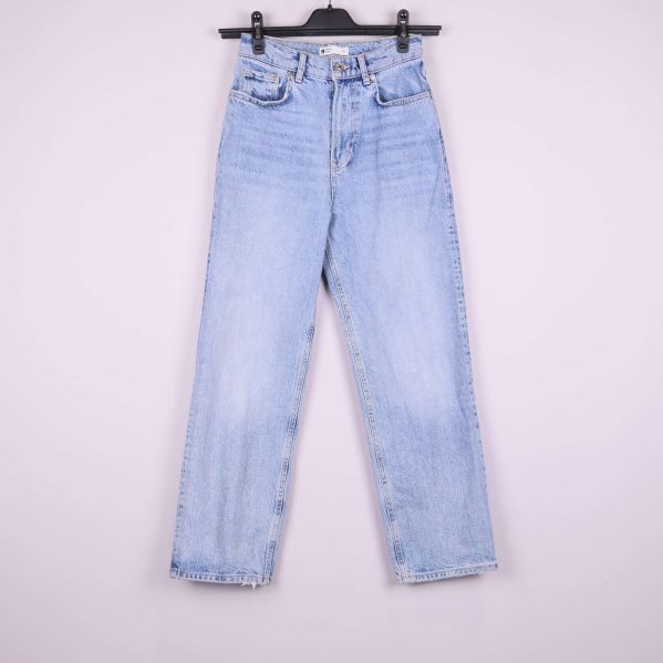 Jeansen framifrån på galge mot ljus bakgrund