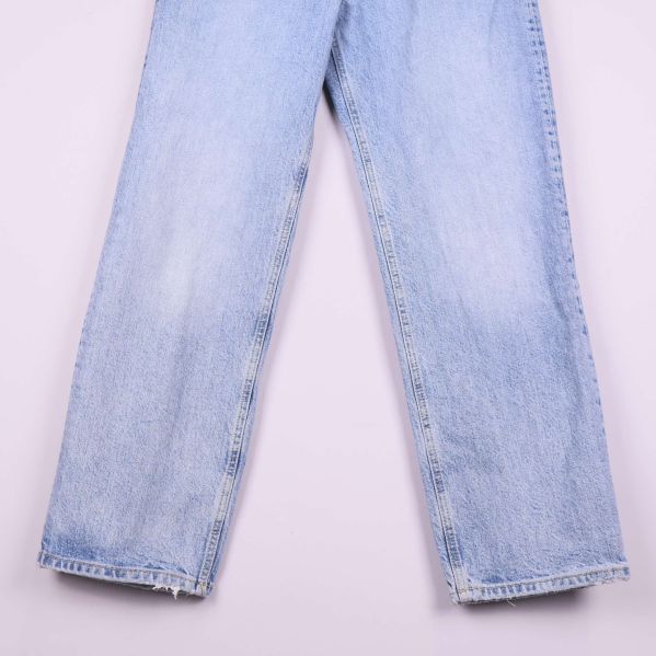 Närbild på jeansens benslut och slitna kanter