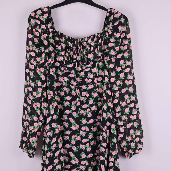 Närbild på överdel och puffärm med rosa blommor