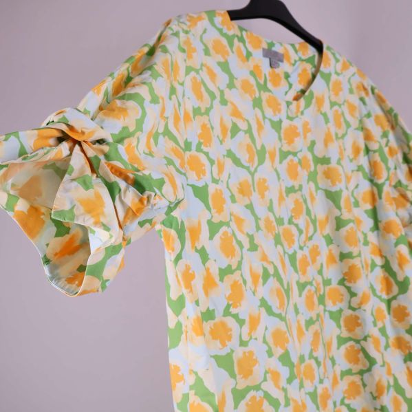 Närbild på ärm med knyt och blommigt tyg