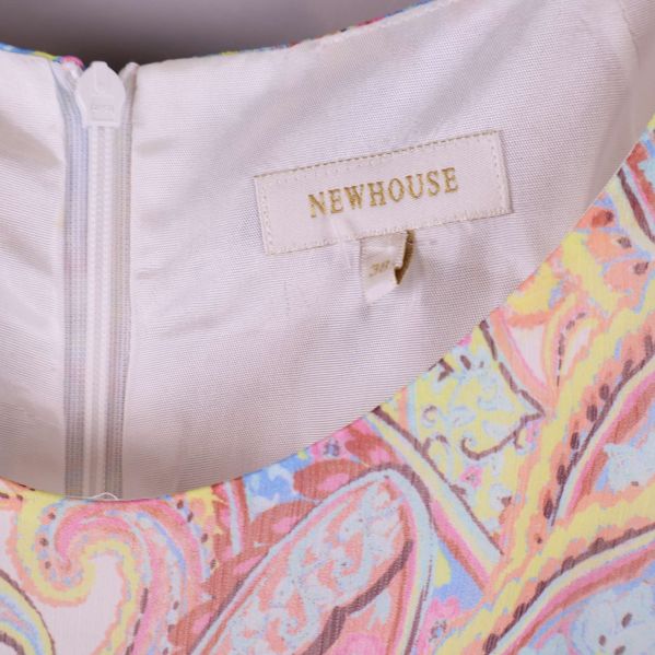 Närbild på Newhouse-märke i nacken på klänningen