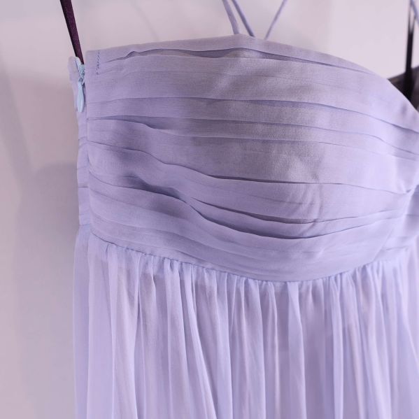 Närbild på överdelens veckade tyg och axelband