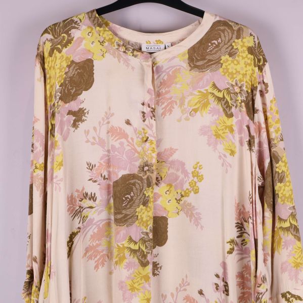Närbild på överdelen av tunikan med blommigt mönster