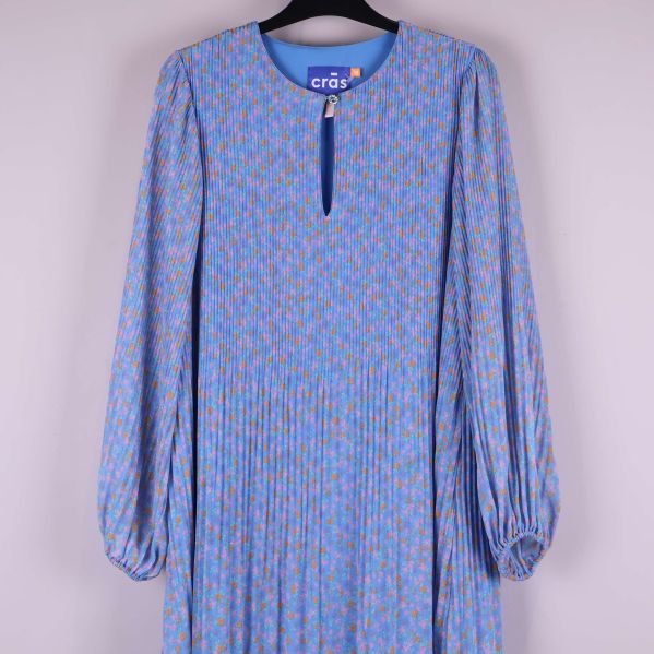 Överkroppsdel på blommig klänning med knappdetalj