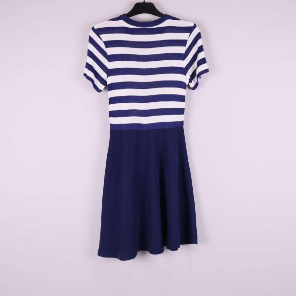 Baksida av klänning med blåvit randig överdel och marinblå kjol