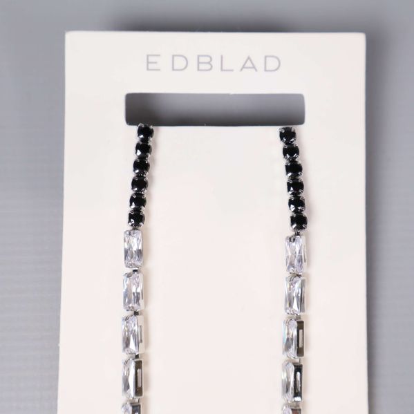 Örhängenas övre del med svart och klar pärlrad visas närmare