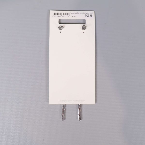 Baksidan på vit kort med örhängen och stift synliga