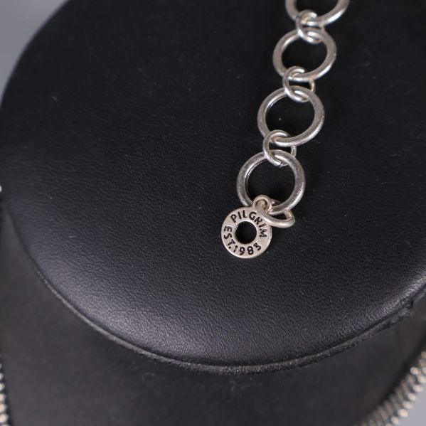 Närbild av märkning Pilgrim EST. 1983 på kedjan