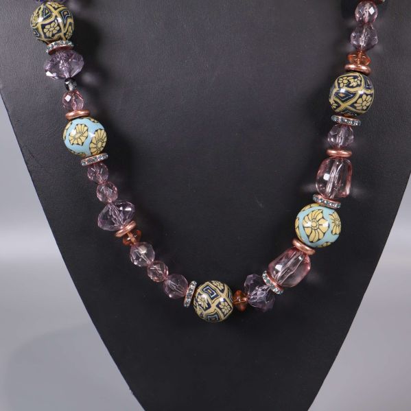 Stora ljusblå mönstrade pärlor bland glaspärlor