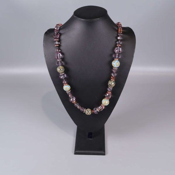 Halsband ordnat på svart ställning med pärlor och dekorationer