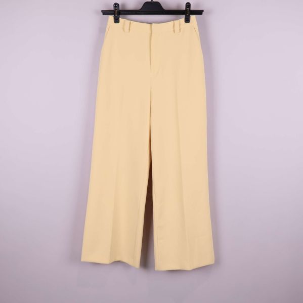 Vida ljusgula byxor upphängda framifrån