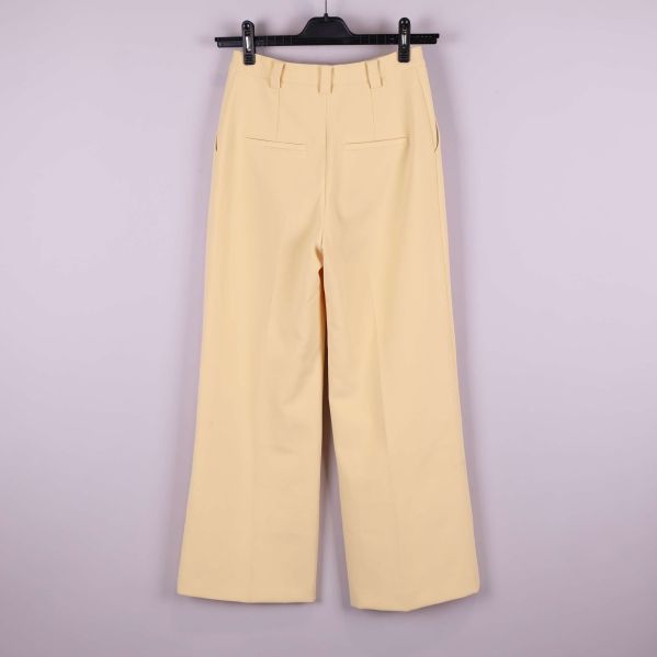 Vida ljusgula byxor visade bakifrån med fickor