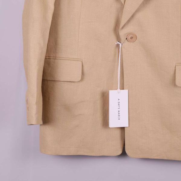 Kavajens framficka och knapp visas närbild