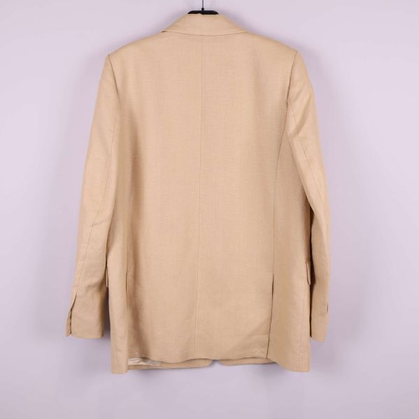 Baksida av beige kavaj på galge