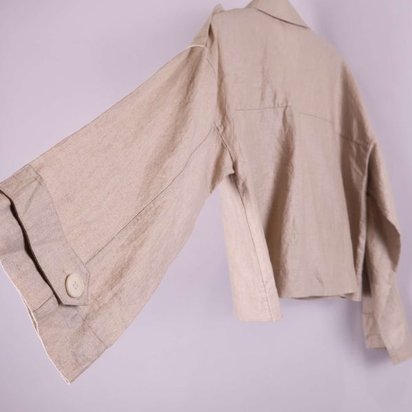 Närbild på jackans ärmslut och knappdetalj