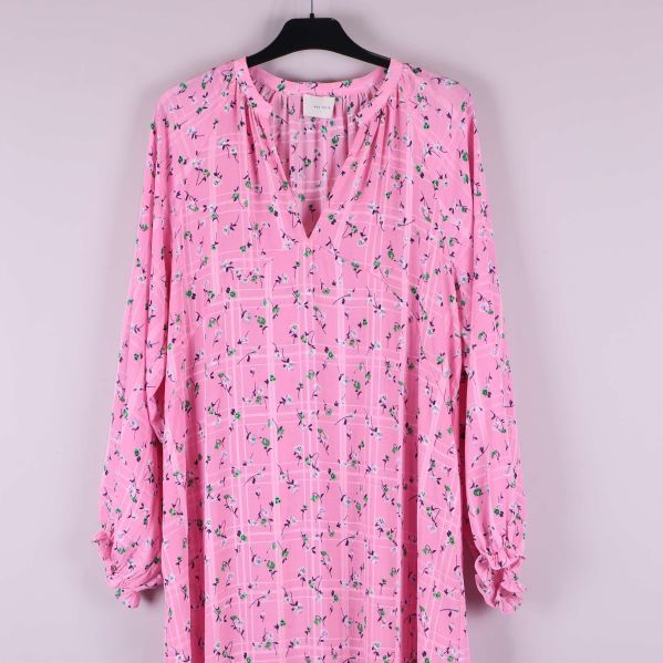 Övre delen av långärmad rosa klänning med mönster