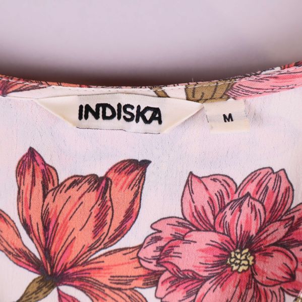 Närbild på Indiska-märke och storlekslapp M i halsen