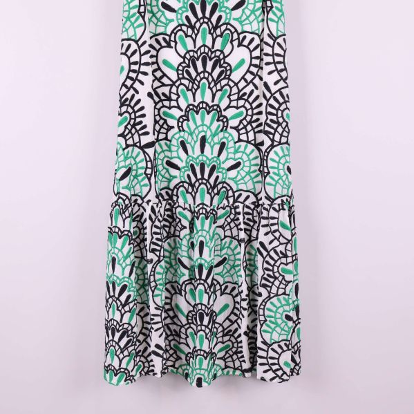 Närbild på nederdelen av klänningen med svartgrönt grafiskt mönster