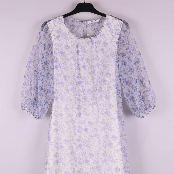 Närbild på puffärm och blommigt tyg