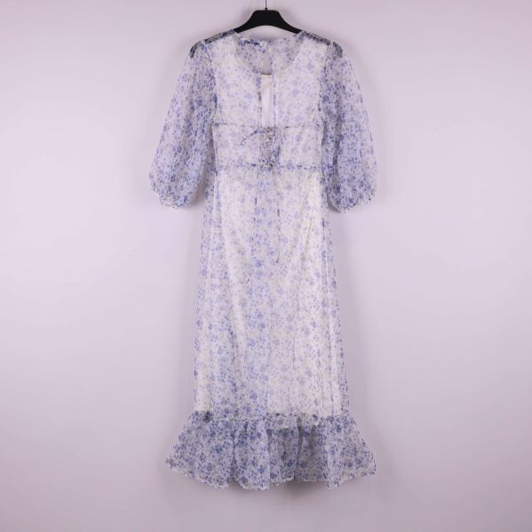 Klänning med blått blommönster sedd bakifrån