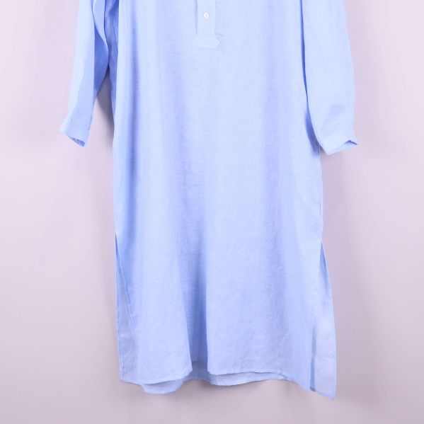 Nedre delen av blå skjortklänning med sidoslitsar