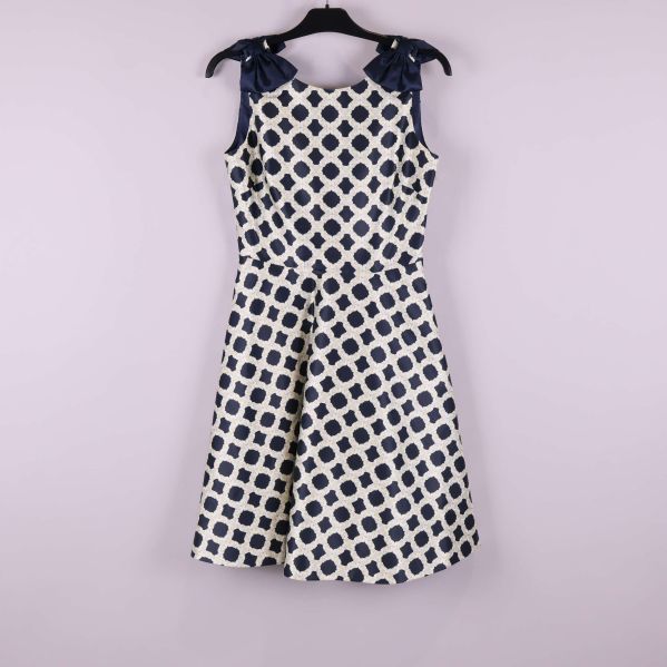 Framsidan av blåvit klänning med rosettdetaljer på axlarna