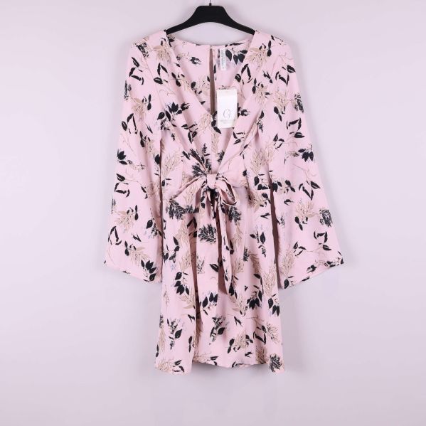 Ljusrosa blommig klänning på galge sedd framifrån