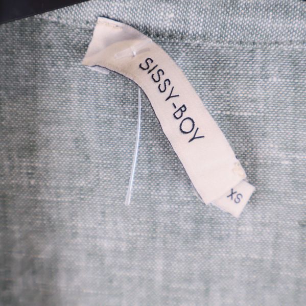 Närbild på etikett med SISSY-BOY och storlek XS