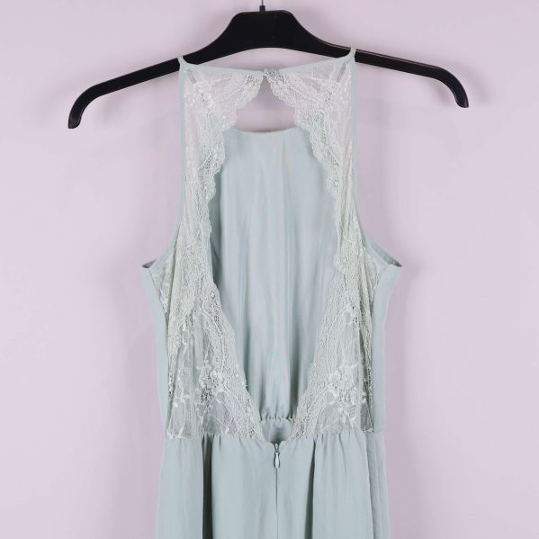 Närbild på spetsdetalj och öppning vid rygg på klänningen