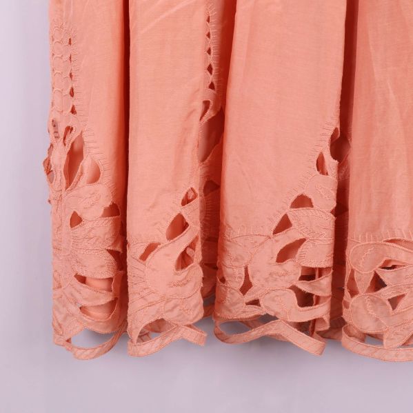 Närbild på dekorerad nederkant av aprikos klänning