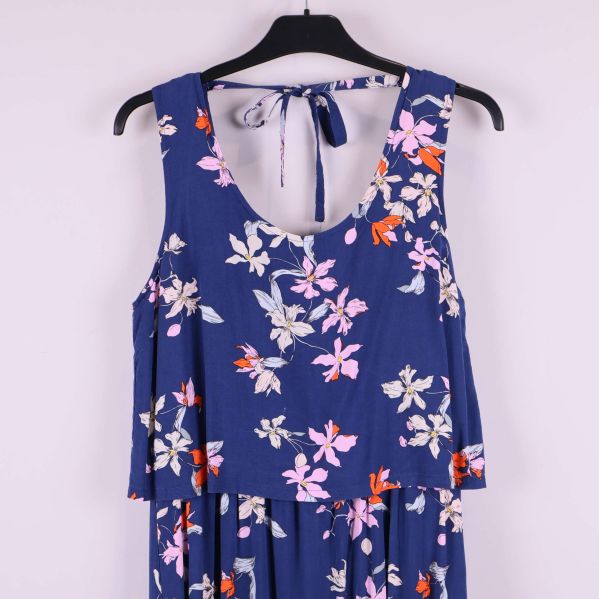 Överkropp på blå klänning med blommigt mönster och knytband
