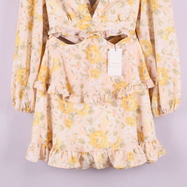 Närbild på blommigt mönster och volang på kjolen