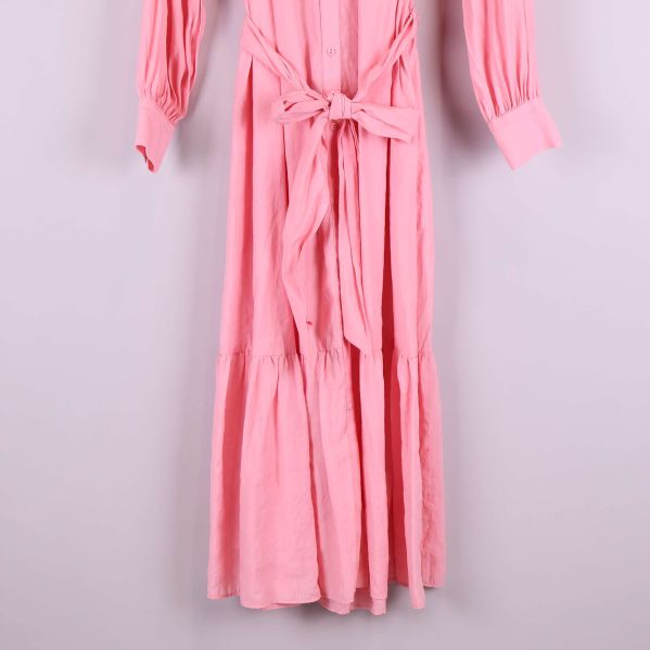 Nedre delen av lång rosa skjortklänning med volang