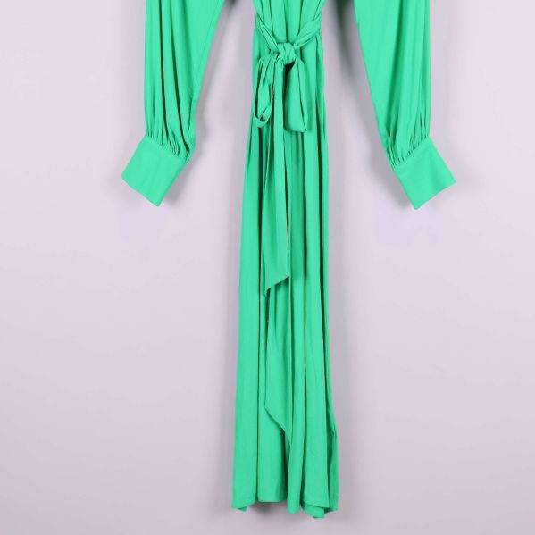 Nedre delen av grön plisserad klänning med midjeknyt