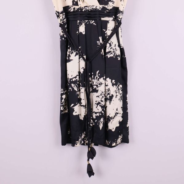 Närbild på midja och knytband med tofs på klänningen