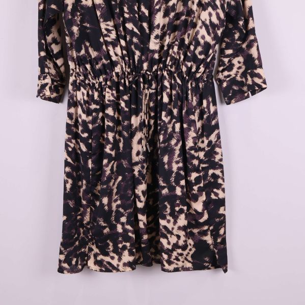 Kjoldetalj på svartbeige mönstrad klänning