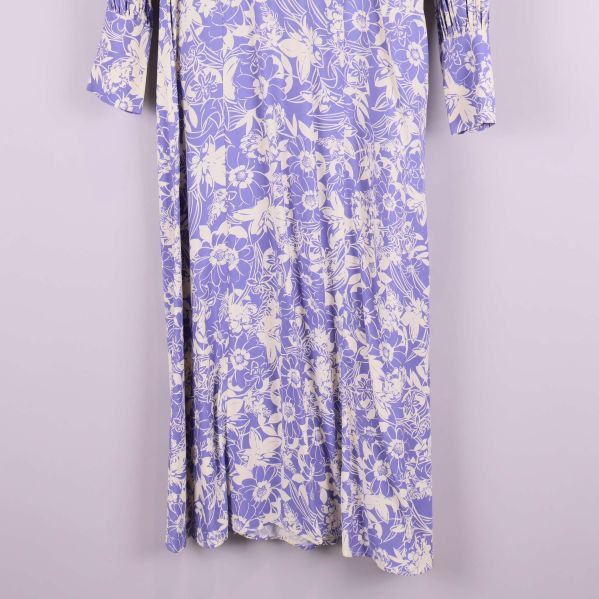 Nederdel av lång blommig lila klänning, närbild