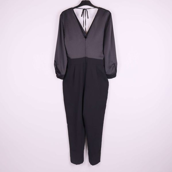 Baksida av svart jumpsuit med v-ringning och knytband