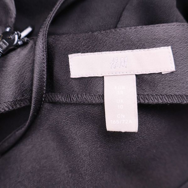 Närbild på H&M etikett och storlekslapp inuti jumpsuit