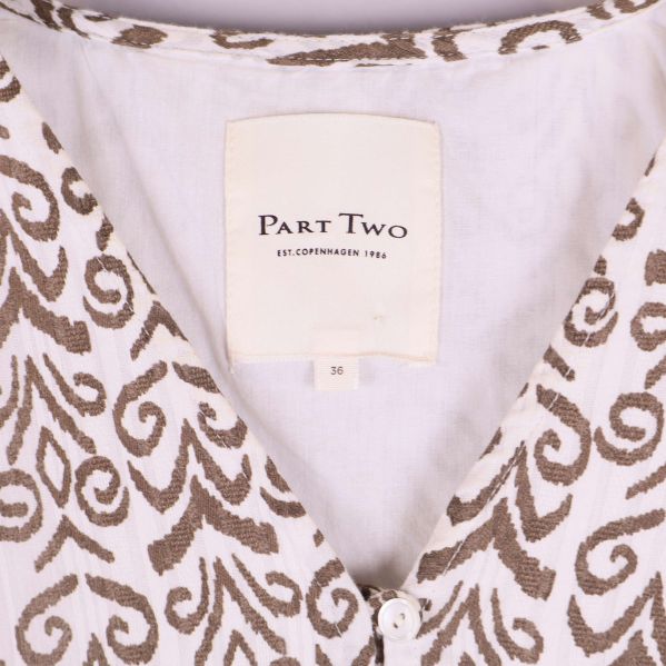 Närbild på Part Two etikett i klänningen vid halsen