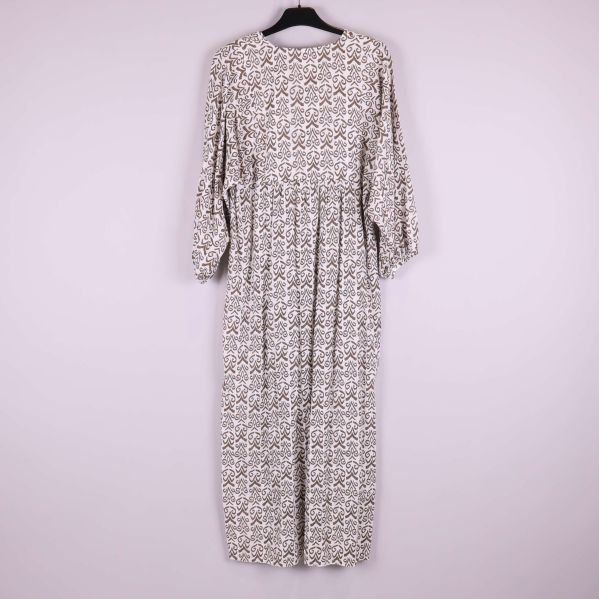 Baksidan av mönstrad långklänning visas på galge