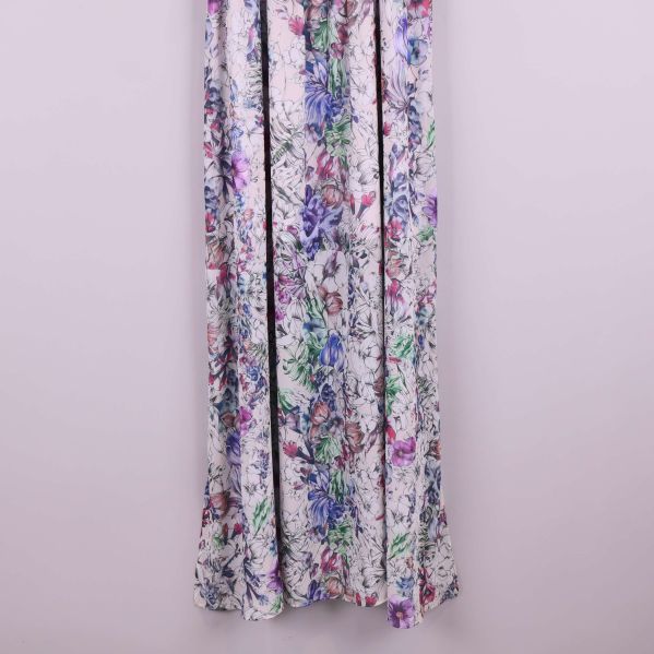 Närbild på nederdelen av blommig långklänning