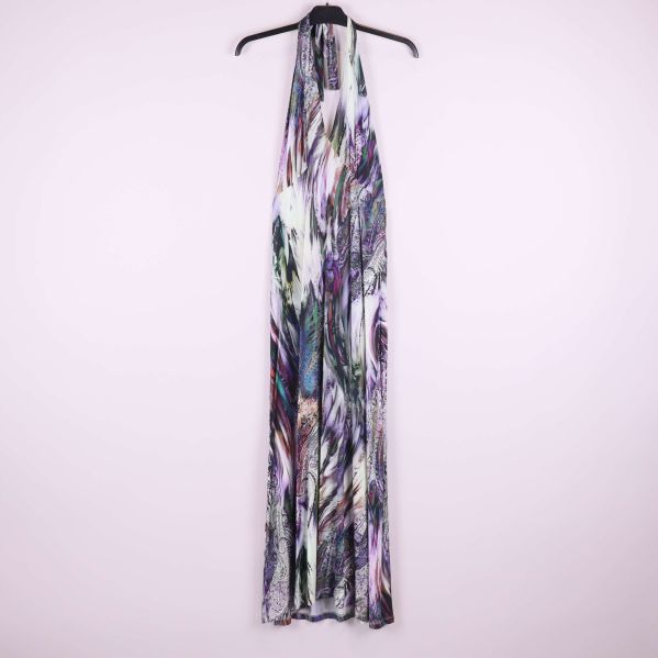 Lång klänning med abstrakt flerfärgat mönster upphängd mot ljus bakgrund