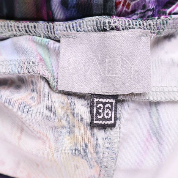 Närbild av Saby-märkeslapp och storlekslapp 36 på klänningen